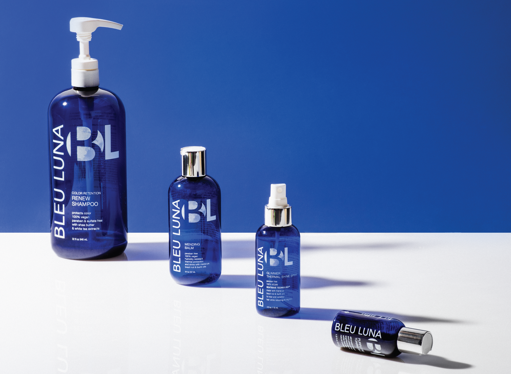 4 blue shampoo bottles with the Bleu Luna logo and labels on them.