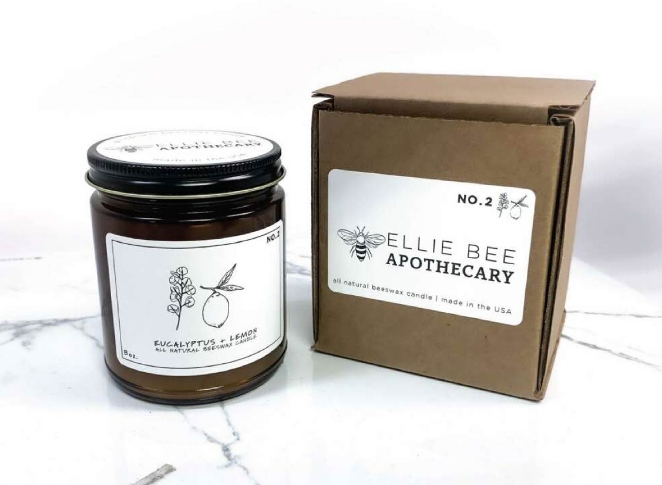 A photo of a eucalyptus and lemon beeswax candle next to its box, showcasing packaging and brand design.